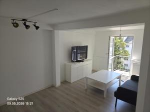 a living room with a tv and a table at Malamin Ludwigshafen in Ludwigshafen am Rhein +8 photos