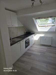a kitchen with white cabinets and a skylight at Malamin Ludwigshafen in Ludwigshafen am Rhein