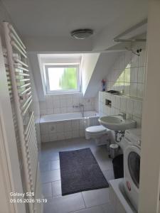 a bathroom with a sink and a tub and a toilet at Malamin Ludwigshafen in Ludwigshafen am Rhein