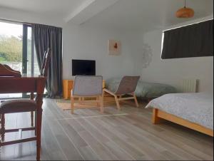a bedroom with a bed and a desk and a piano at La Picardière in Perdreauville