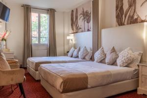 a hotel room with two beds and a window at HOTEL ROYAL Paris Ivry in Ivry-sur-Seine