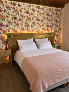 a bedroom with a large bed with a floral wallpaper at Hôtel Aghjola in Pioggiola