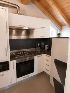 a kitchen with white cabinets and a stove top oven at Mansarda Boutique May in Bergamo