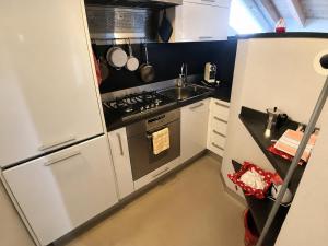 a small kitchen with a stove and a sink at Mansarda Boutique May in Bergamo +8 photos