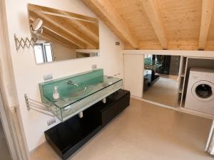 a bathroom with a sink and a washing machine at Mansarda Boutique May in Bergamo