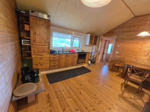 a kitchen with wooden cabinets and a wooden floor at Mara Ház in Lengyel