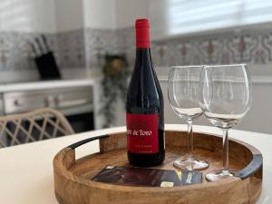 a bottle of wine and two wine glasses on a table at Casa Mirador in Loja