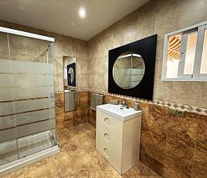 a bathroom with a sink and a shower and a mirror at Casa Mirador in Loja