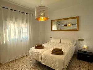 a bedroom with a white bed and a mirror at Casa Mirador in Loja