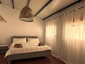 a bedroom with a bed with white sheets and a window at Casa Mirador in Loja +5 photos