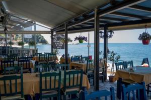 a restaurant with tables and chairs and the ocean at Remezzo Guesthouse in Agios Ioannis Pelio