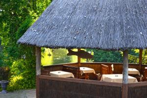 a restaurant with tables and chairs and a thatched roof at Čarda Ranč in Berava