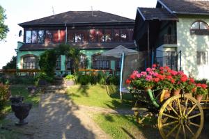 a house with a cart with flowers in front of it at Čarda Ranč in Berava