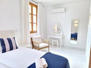 a white bedroom with a bed and a chair at Ca Na Luisa-Residential Area in Palmanova +22 photos
