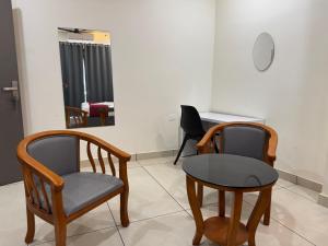two chairs and a table in a room at RIVULET River Side Budget Business Class Hotel in Mukkam