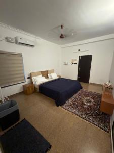 a bedroom with a bed with a blue comforter at The Golden, Apartrooms in Trivandrum
