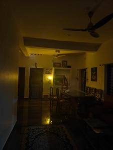 a dark room with a dining room table and chairs at Phoenix Villa in Kappil