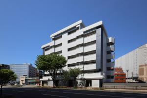 a tall white building on the side of a street at Desroches House in Kanazawa +265 photos