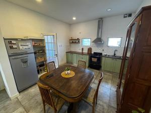 a kitchen with a wooden table and a refrigerator at Dambofamily in Necochea