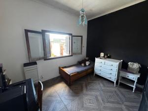 a bedroom with a bed and a dresser and a window at Dambofamily in Necochea