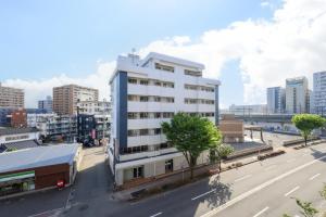 a white building on the side of a city street at Desroches House in Kanazawa