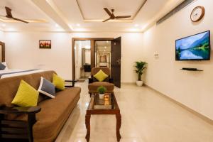 a living room with a couch and a tv at Hotel Comfort Park - Opposite Sri Ramachandra Medical College Porur in Chennai