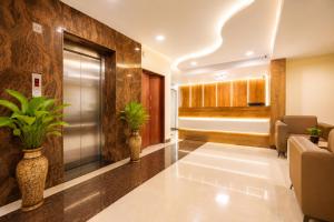 an office lobby with plants in vases on the wall at Hotel Comfort Park - Opposite Sri Ramachandra Medical College Porur in Chennai +40 photos