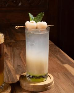a drink sitting on a wooden table with a stick at Griya Yunika in Yogyakarta