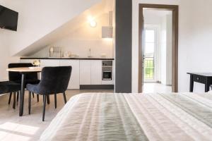 ein Schlafzimmer mit Bett und Tisch und eine Küche in der Unterkunft "Trakaitis" apartments & holiday homes in Trakai
