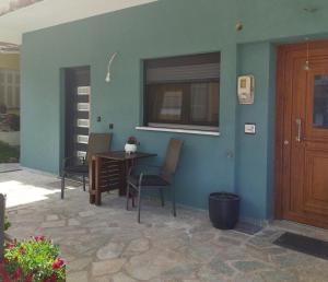 a room with a table and chairs and a blue wall at The swanky studio in Anatolí