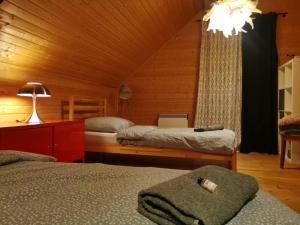 a bedroom with three beds and a chandelier at Pauza Drzewoszewo - Dom nad jeziorem in Drzewoszewo