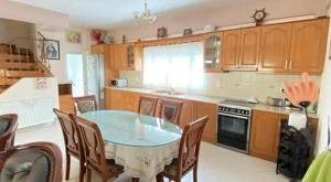 a kitchen with a table and chairs in a kitchen at Family Home in Amarynthos