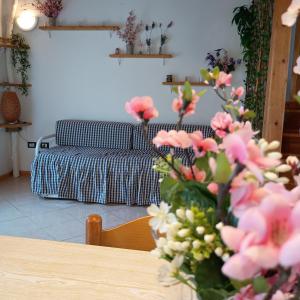 a living room with a table with pink flowers at La Casa del Zuf in Carlino