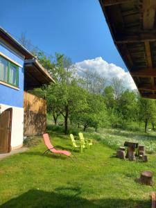 a group of chairs sitting in the grass next to a building at Casa La Casiru 17 nature in Straja