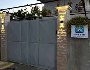 a gray garage door with a sign on it at Floor Villa 2 in Vlorë +4 photos
