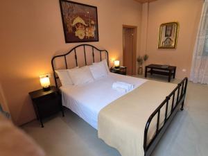 a bedroom with a large bed and two lamps at Apartment Rustico in Ancient Epidauros