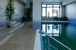 a swimming pool in a building with blue tiles at Hotel Doina 2 Tasnad in Tăşnad +13 photos