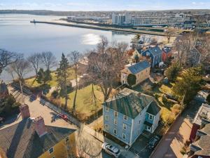 an aerial view of a city with a large house and water at Steps to Derby Wharf and Gables. in Salem
