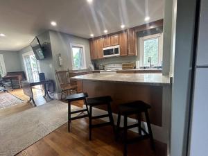 a kitchen with a counter and stools in a room at Steps to Derby Wharf and Gables. in Salem