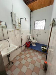 a bathroom with a toilet and a sink at Lingkudau Homestay in Keningau +10 photos