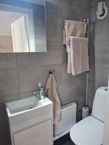 a bathroom with a sink and a toilet and towels at Boende i Falkenberg in Falkenberg
