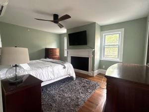 a bedroom with a bed with a fireplace and a tv at Steps to Derby Wharf and Gables. in Salem