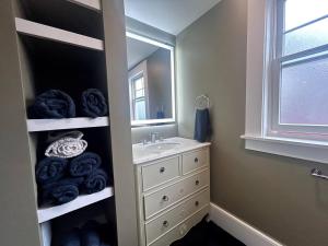 a bathroom with a sink and a mirror at Steps to Derby Wharf and Gables. in Salem +10 photos