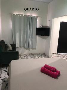 a bedroom with a bed with a red pillow on it at Pousada Aruanã in Soure