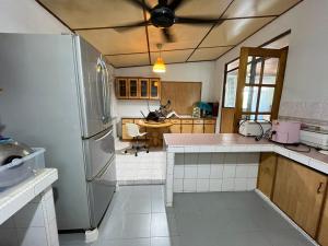 a kitchen with a refrigerator and a table at Lingkudau Homestay in Keningau