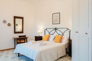 a bedroom with a white bed with orange pillows at Casa degli Ulivi in Ravello