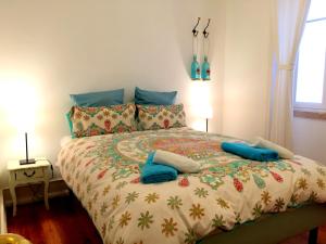 um quarto com uma cama grande e almofadas azuis em Lisbonera Guest House em Lisboa