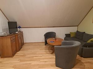 a living room with a couch and a table at Blick zum See in Laasow