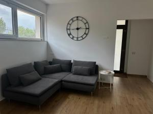 a living room with a couch and a clock on the wall at Residenza Dottavio in Montenero di Bisaccia +20 photos