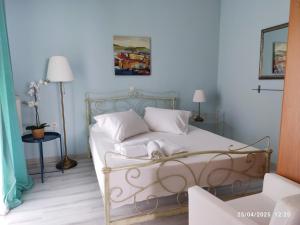 una camera da letto con un letto con lenzuola e cuscini bianchi di Morfi a Città di Lefkada
